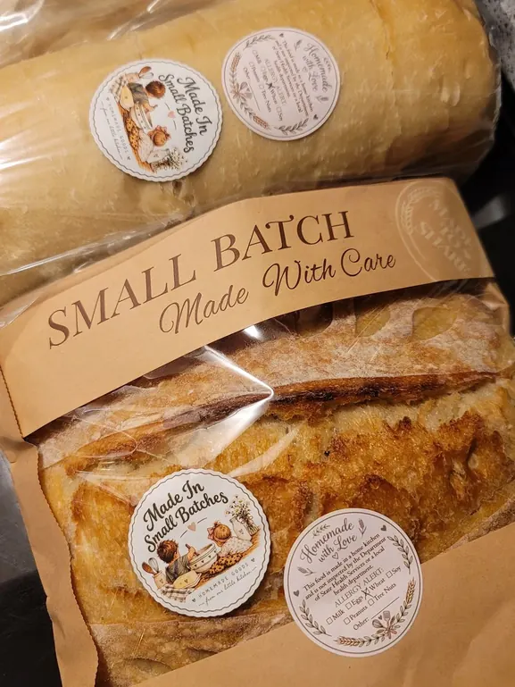 Sandwich loaves and an OG sourdough wrapped and labeled with Made In Small Batches stickers