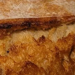 A golden OG sourdough loaf in a kraft “Small Batch” bag with Made In Small Batches stickers